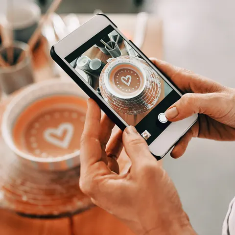 Arte latte fotografiado con un celular para una publicación de café