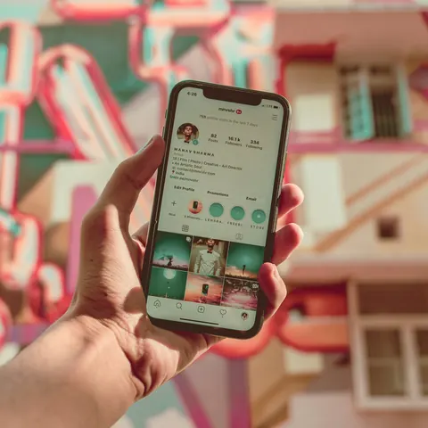 Mano sosteniendo un celular con un perfil de Instagram