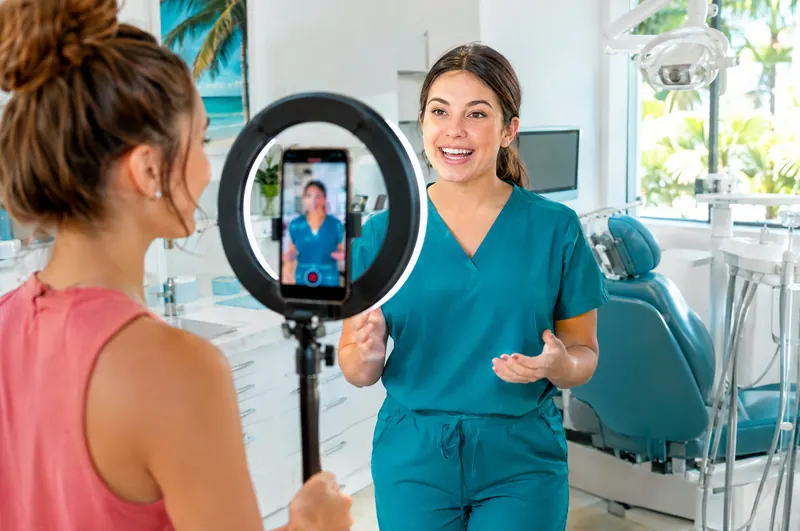Content creator filming a short video with a hygienist using a ring light